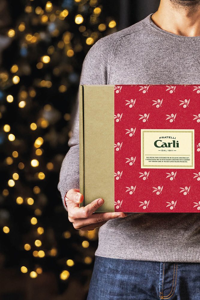 Young man holding a Fratelli Carli gift box in his hands