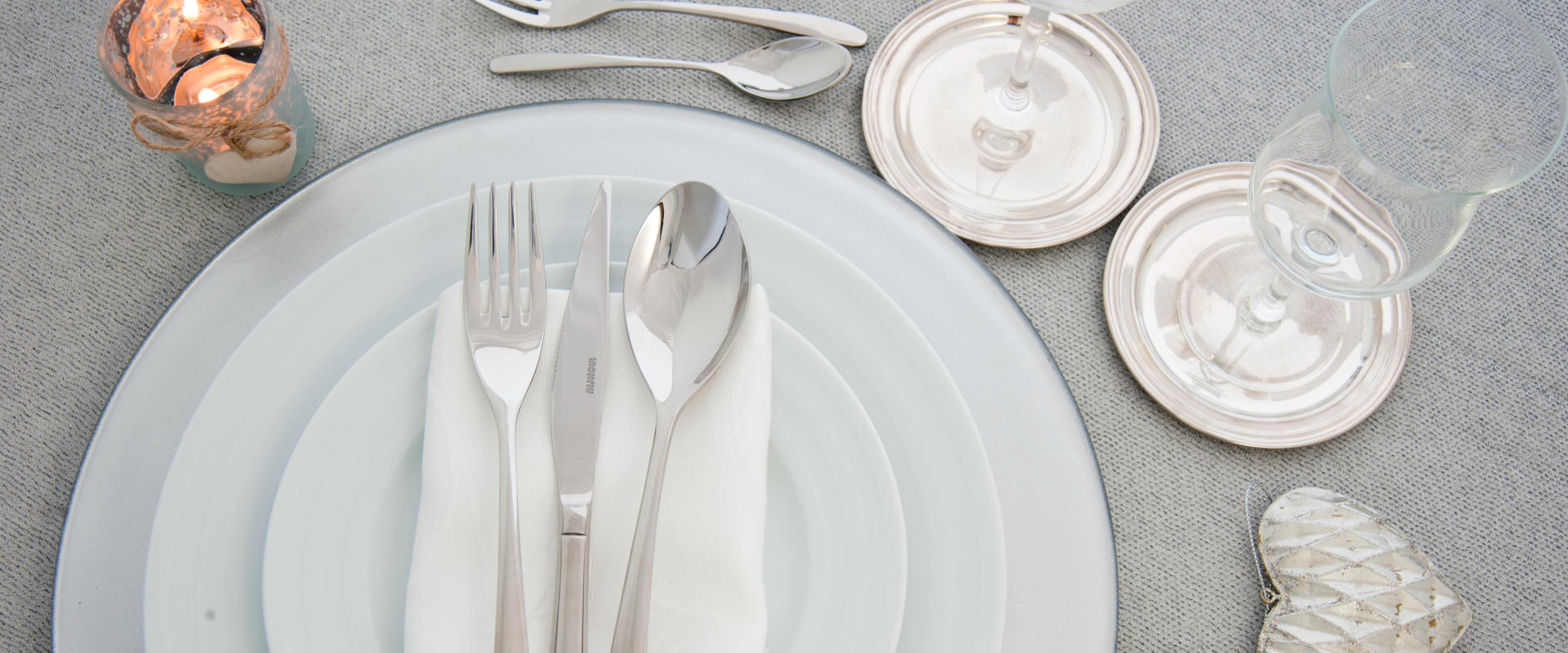 Cutlery, plates and glasses on set table